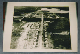 Reproduction d’une vue aérienne de la ville de Chibougamau en 1954. À l’arrière plan, en haut à g...