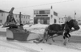 La mascotte et un homme en calèche (chaussure) tiré par des chevaux sur le boulevard Springer aux...