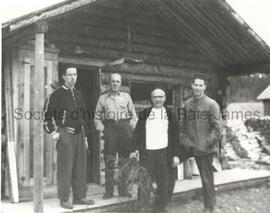 Quatre hommes devant un campement au lac Bourbeau