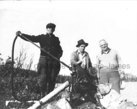 Arthur Forest, Lucien Demers et Larry Wilson près d’une pompe.