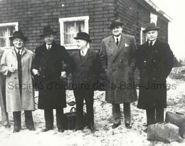 Hommes devant un bâtiment.