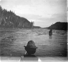 Un homme en canot observe un rapide sur la rivière Ashuapmushuan