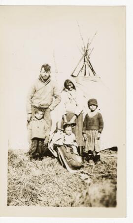 Famille crie devant une tente.