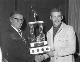 Deux hommes avec un trophée au banquet de clôture de la saison de la ligue Nordair