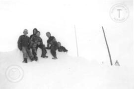 Jeunes sur un banc de neige devant l'école.