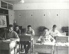 Cinq adolescents dans une classe.