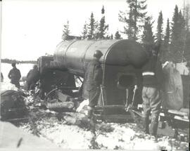 Cinq hommes près d'une bouilloire que 1’on transporte.