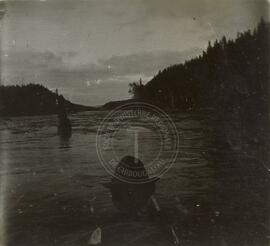 Un homme en canot observe un rapide sur la rivière Ashuapmushuan