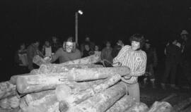 Groupe de personnes dont deux tirant des bûches de bois lors d’un festival de bûcheron à Lebel-su...