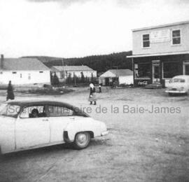 Gens et voiture devant la tabagie à Chibougamau