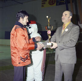 Deux hommes se serrant la main et recevant un trophée au Carnaval 1974
