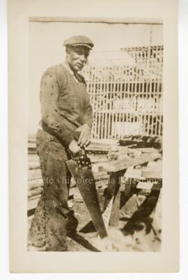 Homme sciant du bois, recouvert de taons.