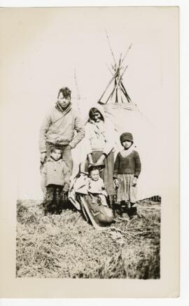 Famille crie devant une tente.