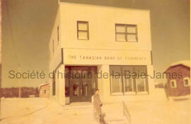 Homme devant la Banque de Commerce.