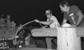 Un homme sciant une bûche lors du festival de bûcheron à Lebel-sur-Quévillon