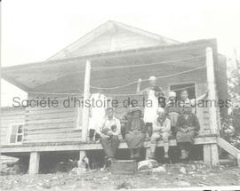 Cinq hommes sur la galerie du campement de la Capital Trades