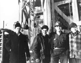 Quatre hommes devant le puits de la mine Campbell.