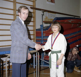 Un enfant et un adulte se serrant la main dans le cadre des compétitions de judo de Lebel-sur-Qué...