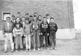Jeunes devant la petite école de quatre(4) classes.