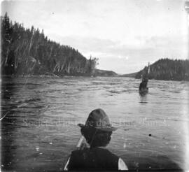 Un homme en canot observe un rapide sur la rivière Ashuapmushuan