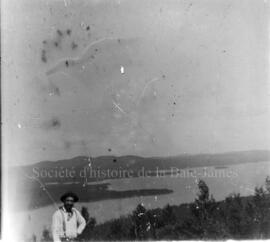 Un homme [guide Innu?] devant un paysage de la région du lac Chibougamau